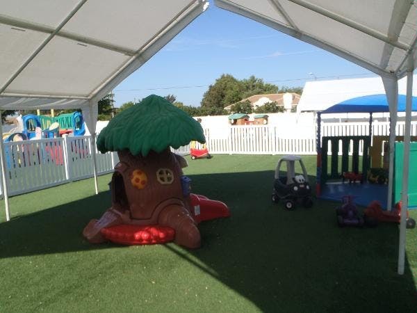 Outdoor play area with a tree-shaped play structure and toy car