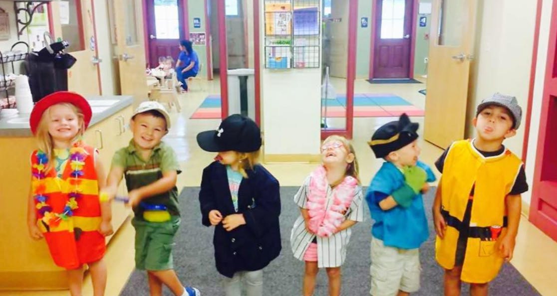 Six children in costumes standing in a row