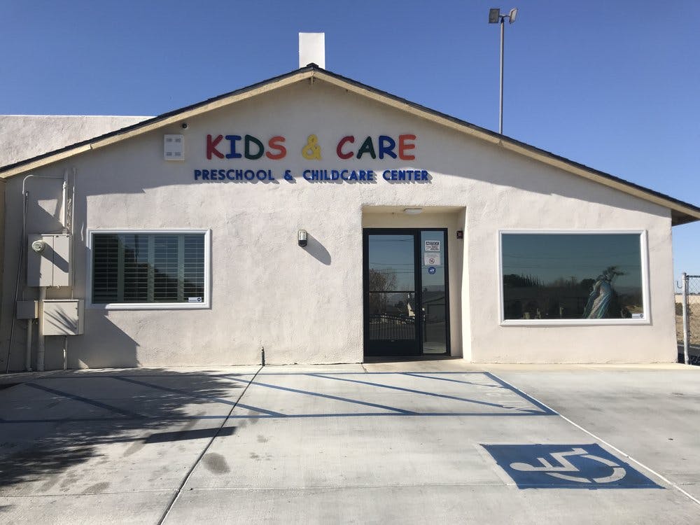 Building with "Kids & Care Preschool & Childcare Center" sign