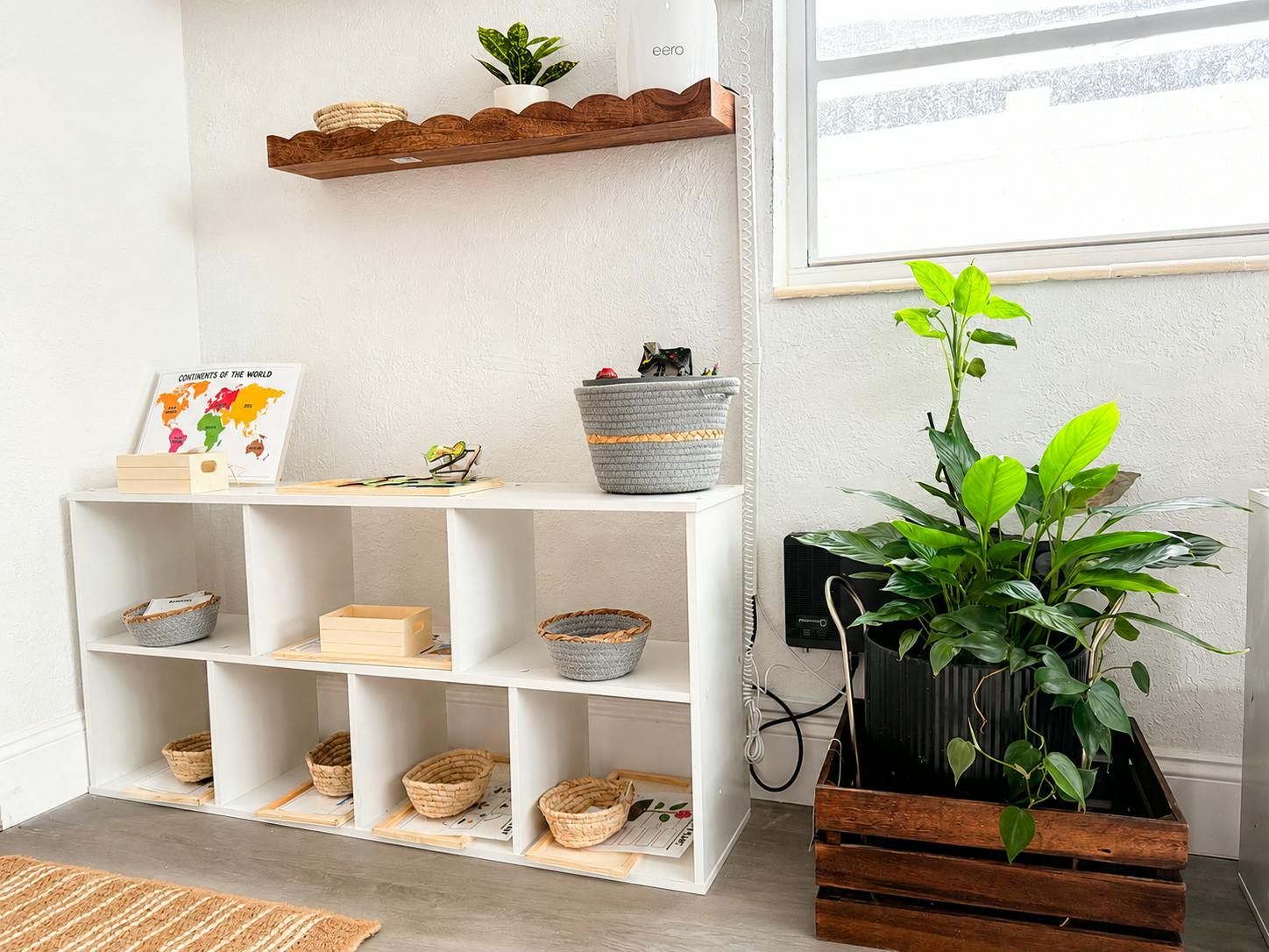 White cube storage shelf with baskets and a world map in a bright room