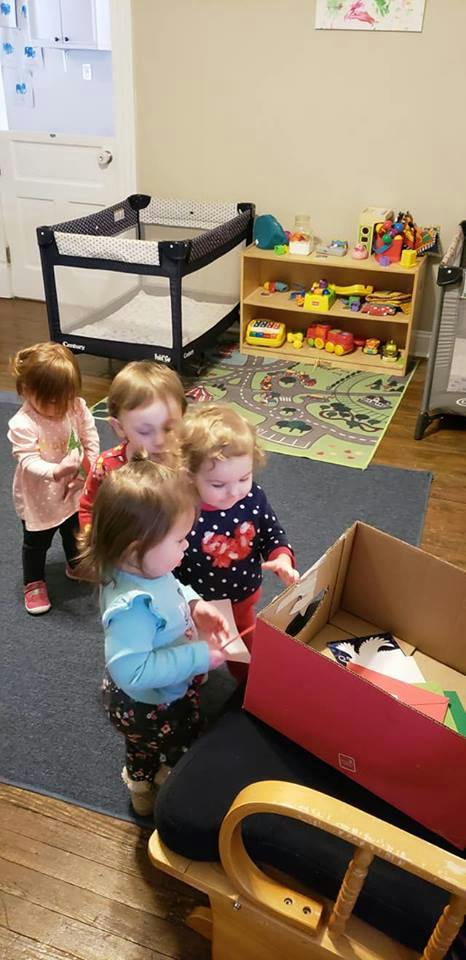 Four children looking into a cardboard box