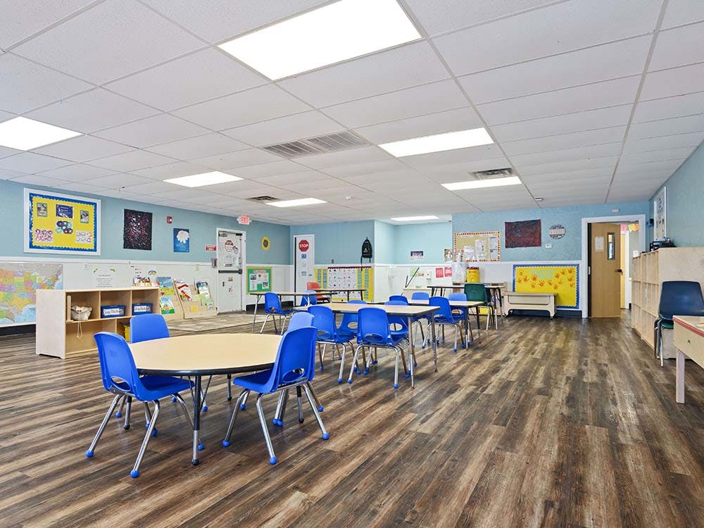 Classroom with small round tables and blue chairs