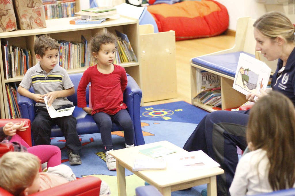 Adult reading a book to children in a classroom
