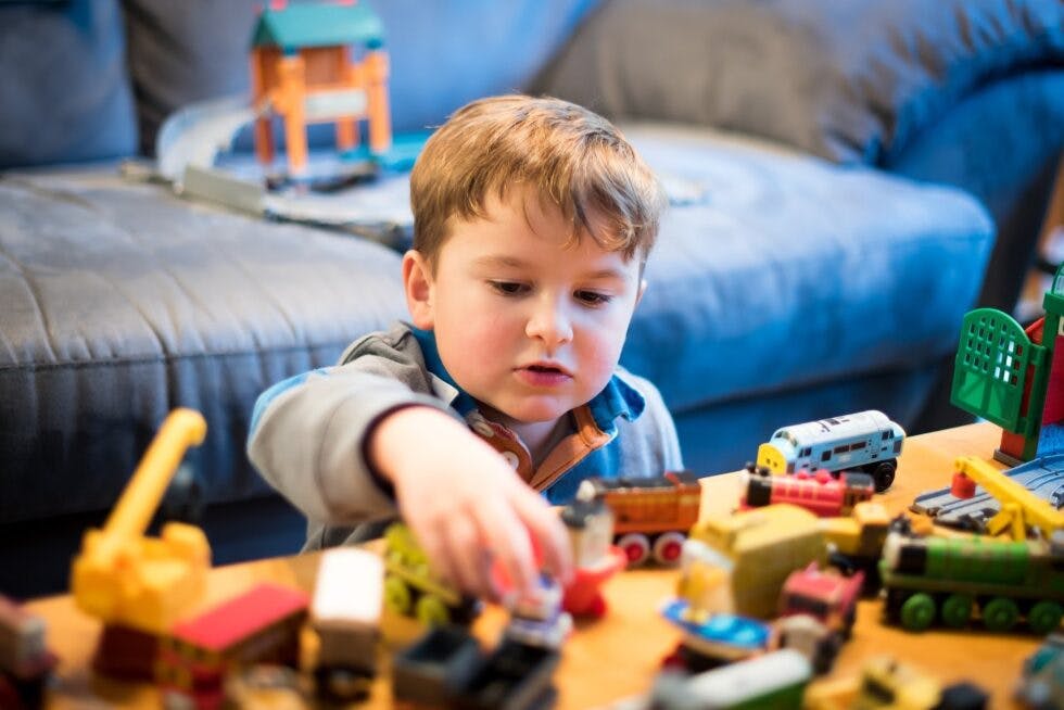 Child playing with toy trains