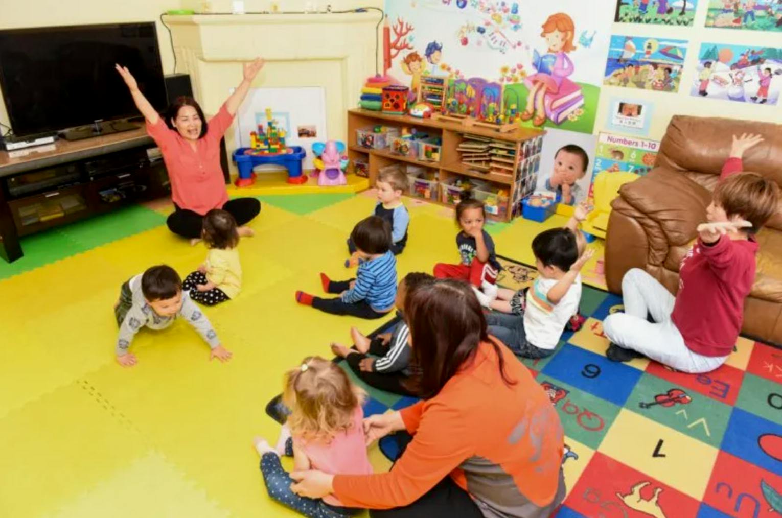 Adults and children participating in a group activity in a playroom