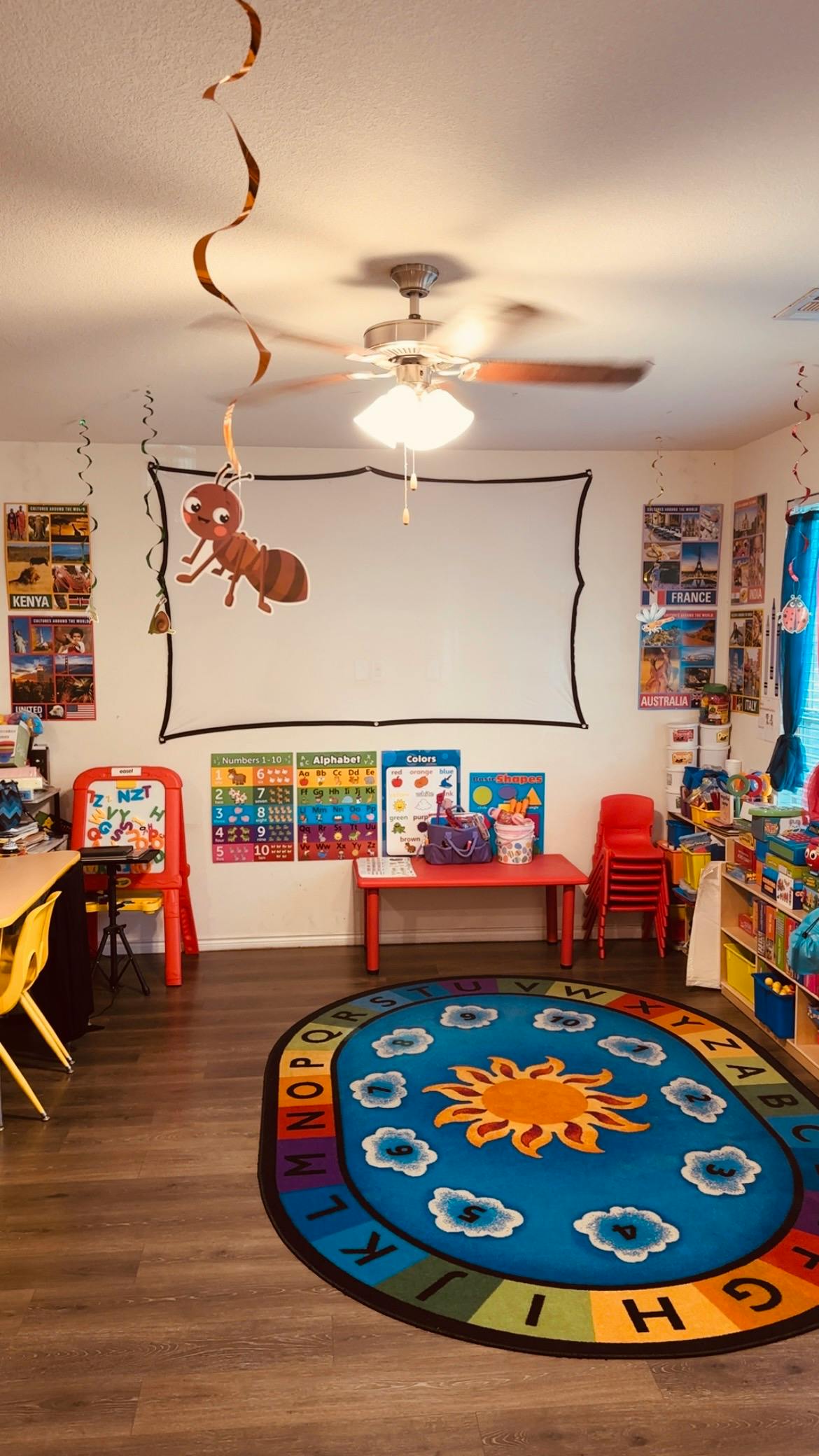 Classroom with a large alphabet rug, small tables, and educational posters