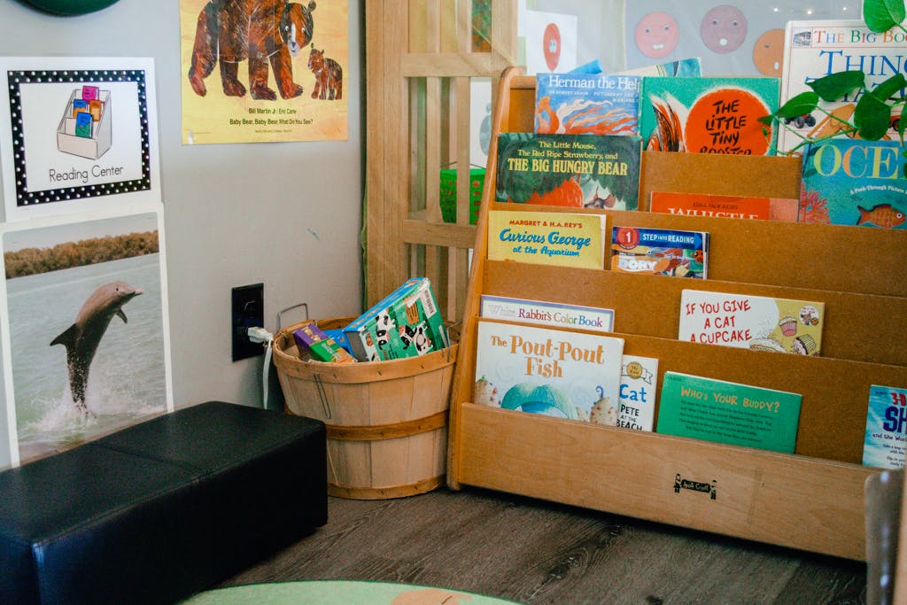 Children's books displayed on a wooden shelf and in a basket