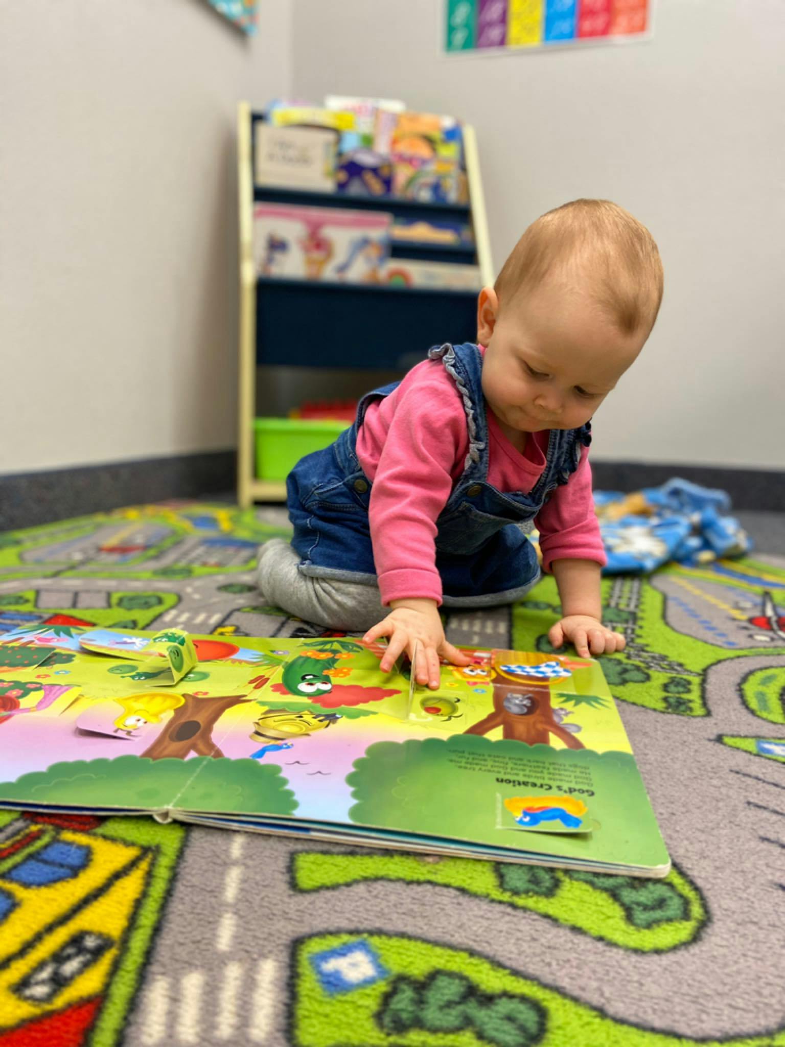 Child on hands and knees looking at a pop-up book