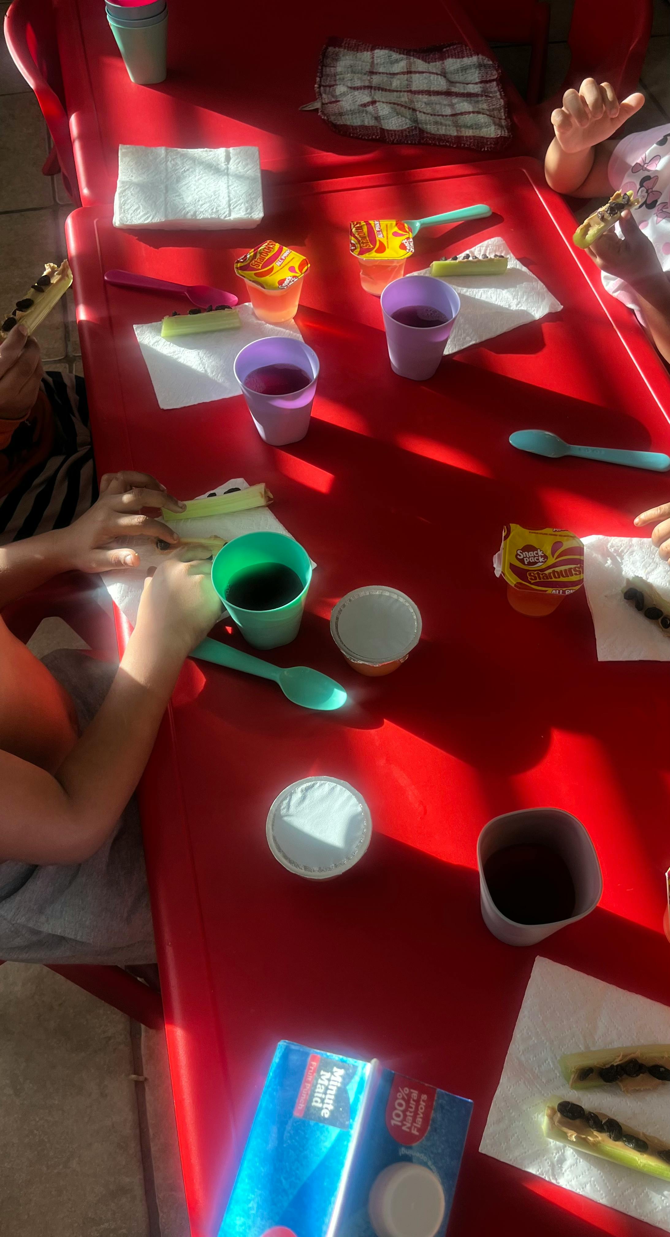 People eating snacks at a red table