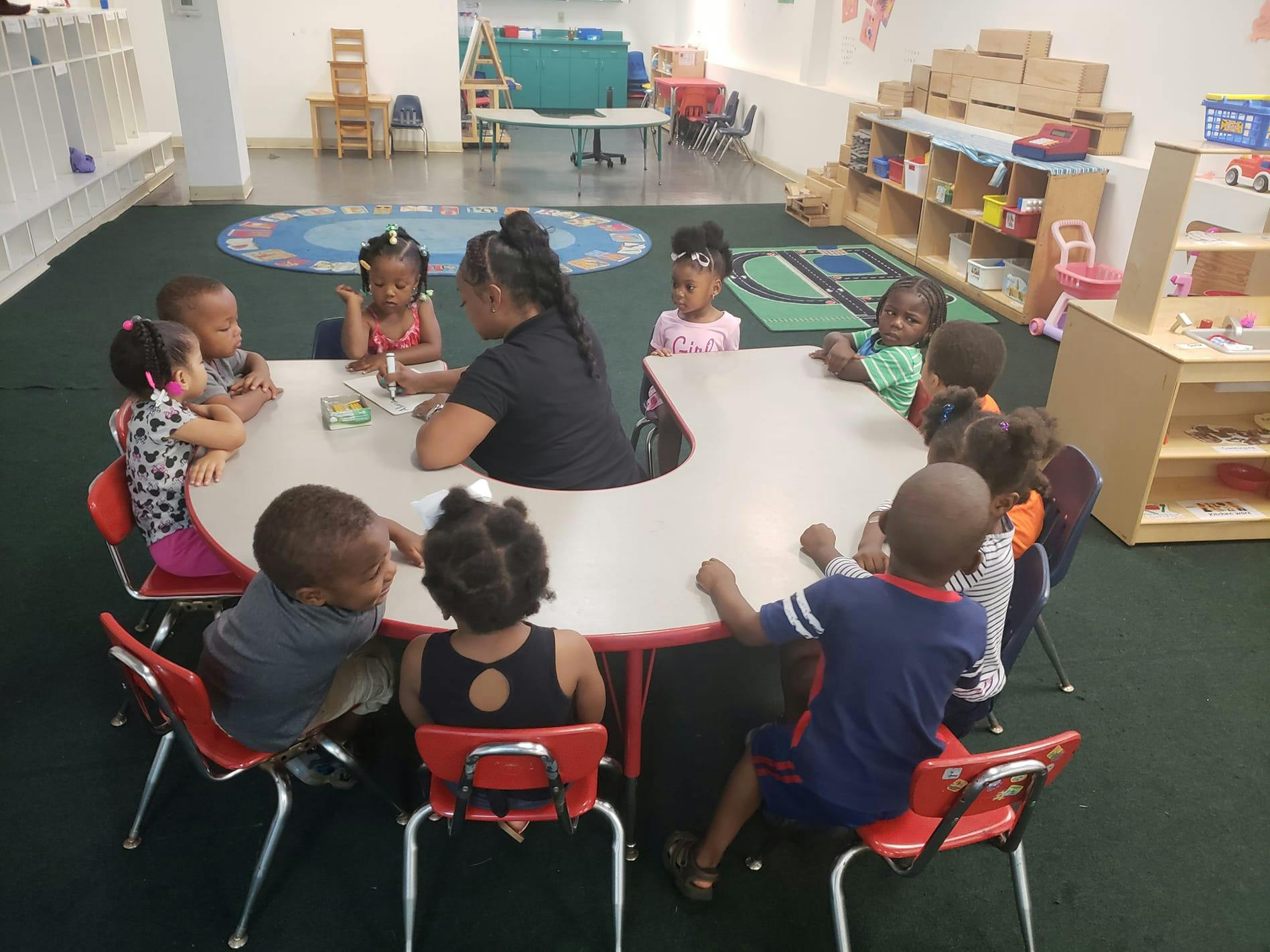 Adult and children sitting around a table in a classroom