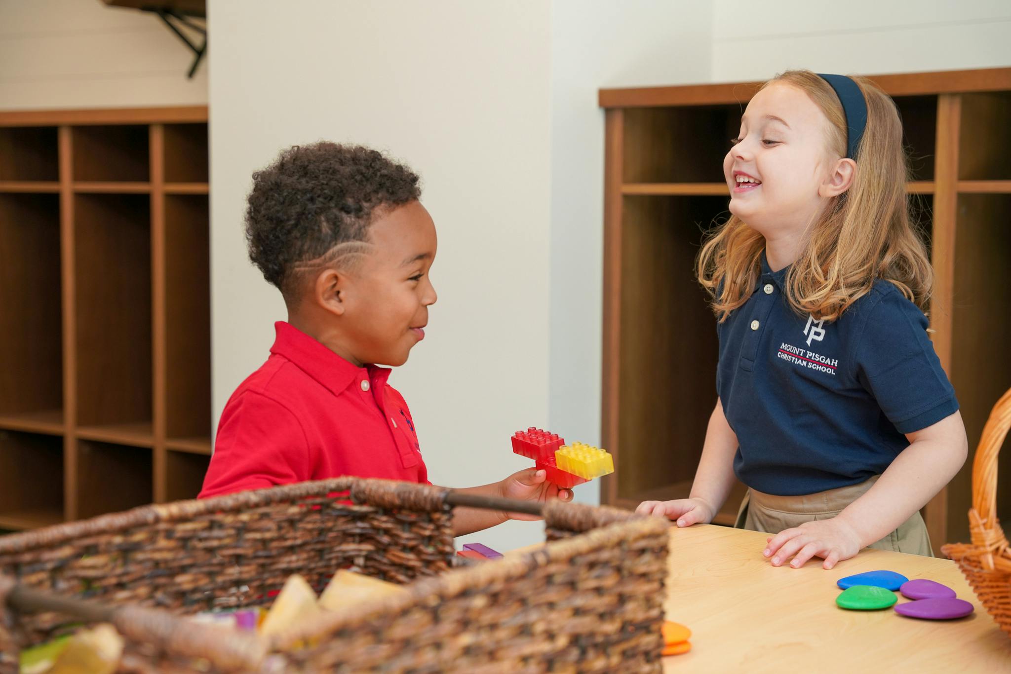 Two children playing with toys in a classroom