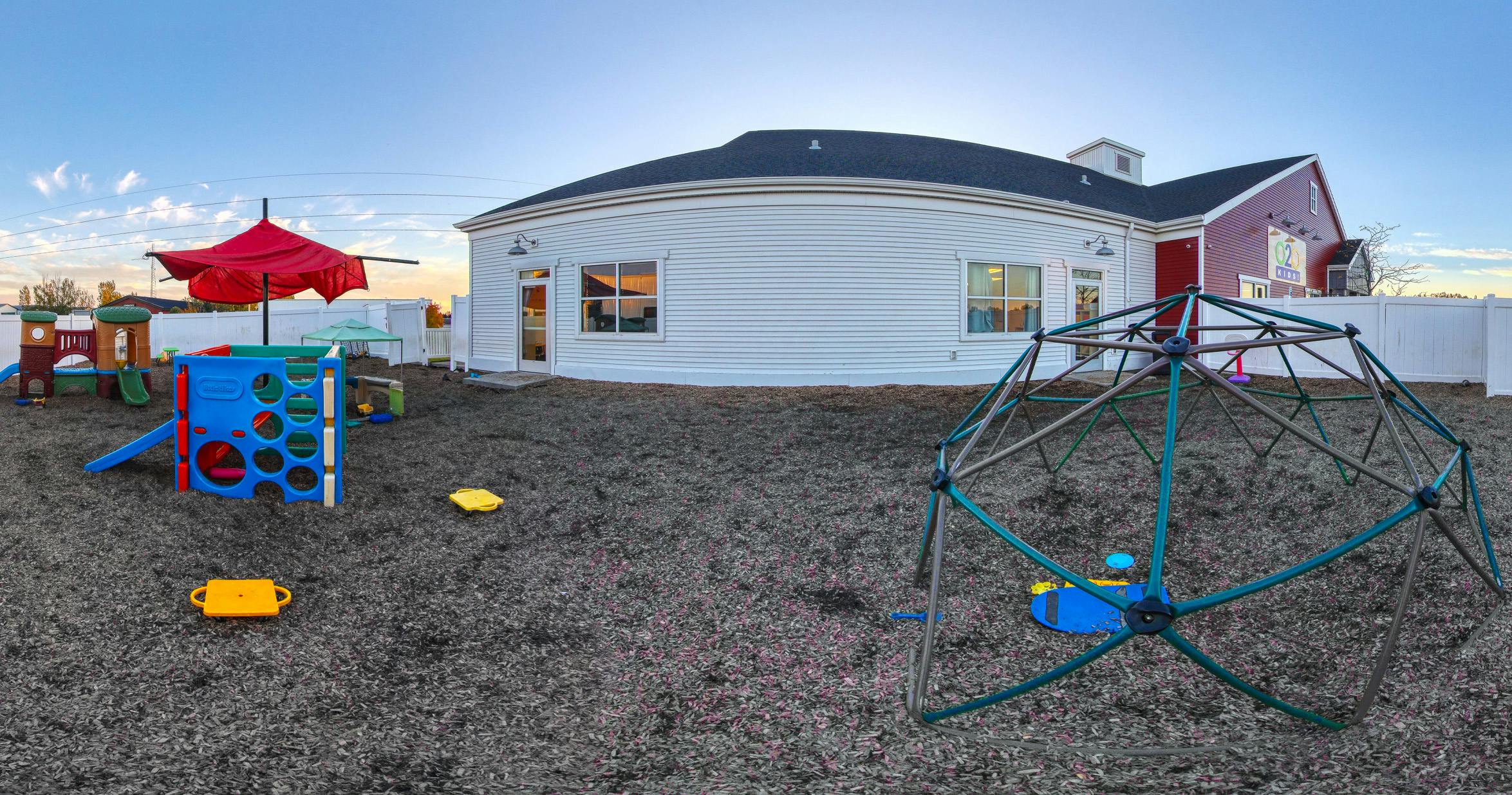Playground with various play structures and a building in the background