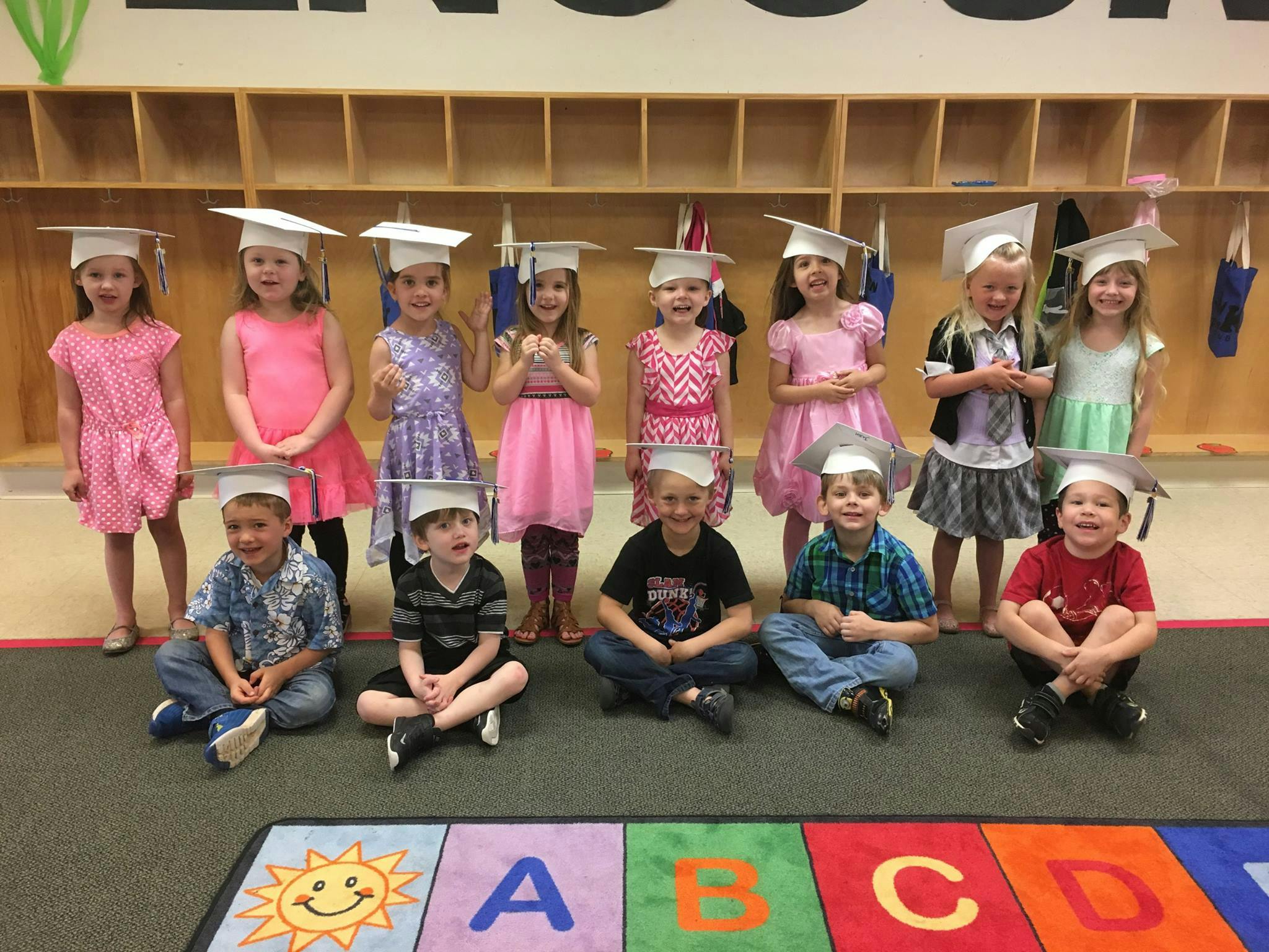 Group of children wearing graduation caps