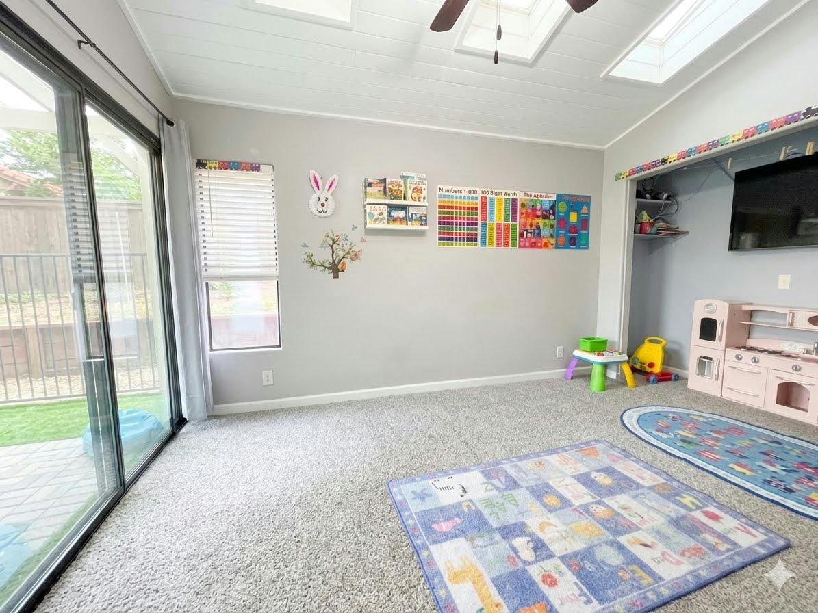 Playroom with educational wall charts, toy kitchen, and patterned rugs