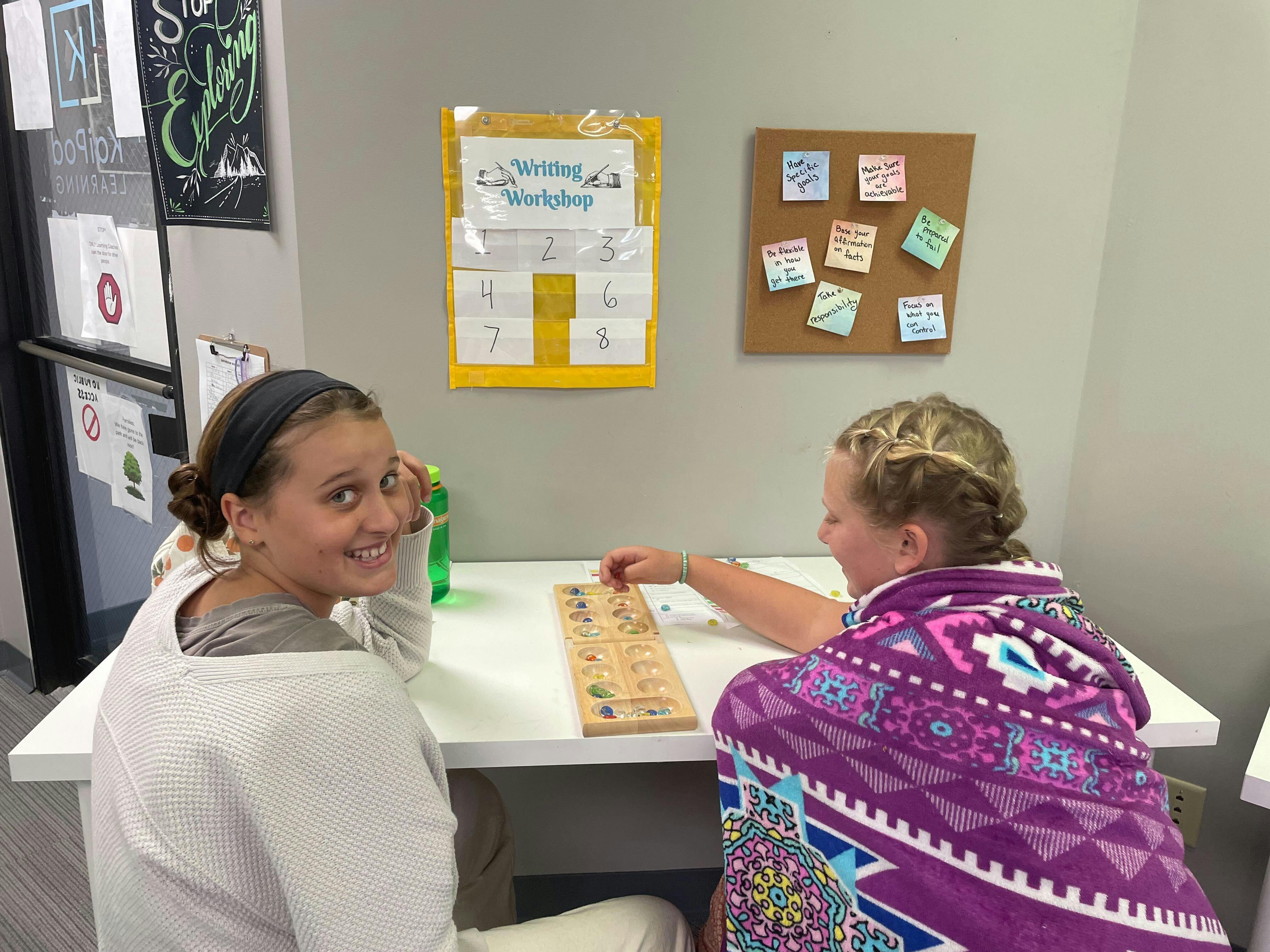 Two children playing a board game at a table