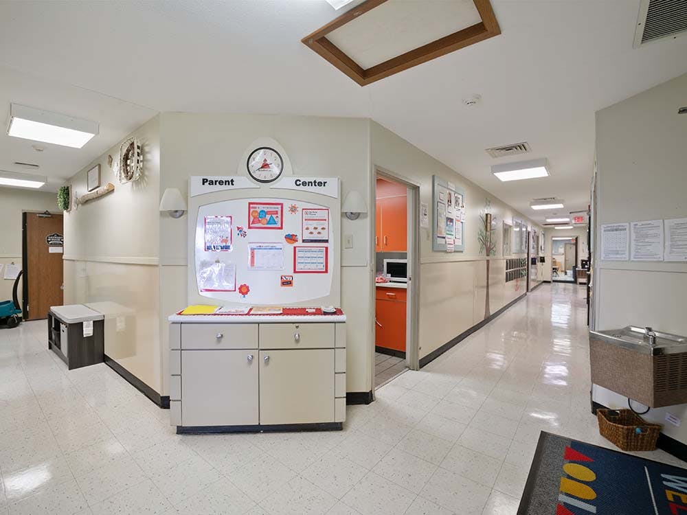 Hallway with a bulletin board labeled "Parent Center" and a long corridor