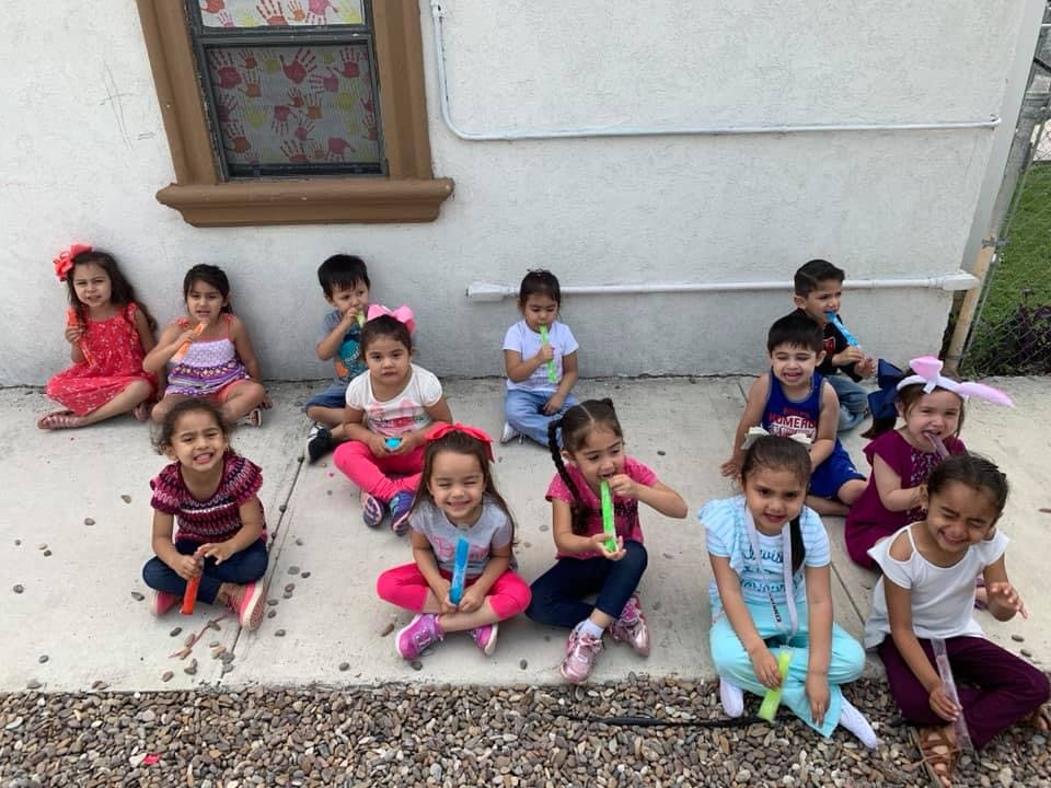Group of children sitting on the ground outdoors