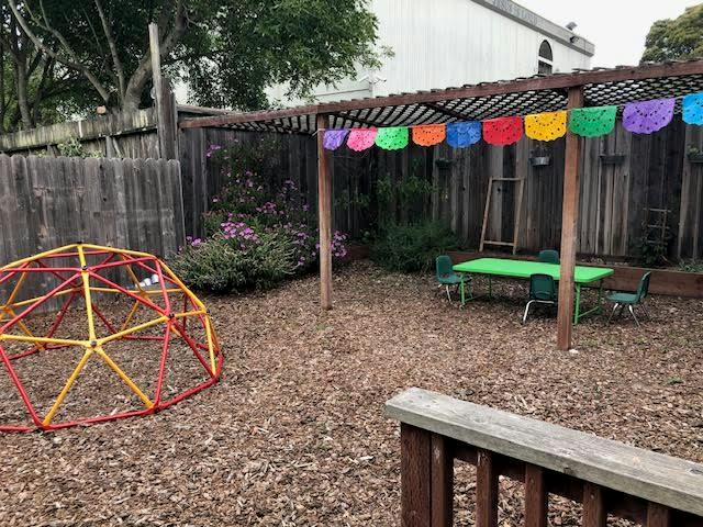 Playground with a geodesic dome climber and a table under a pergola