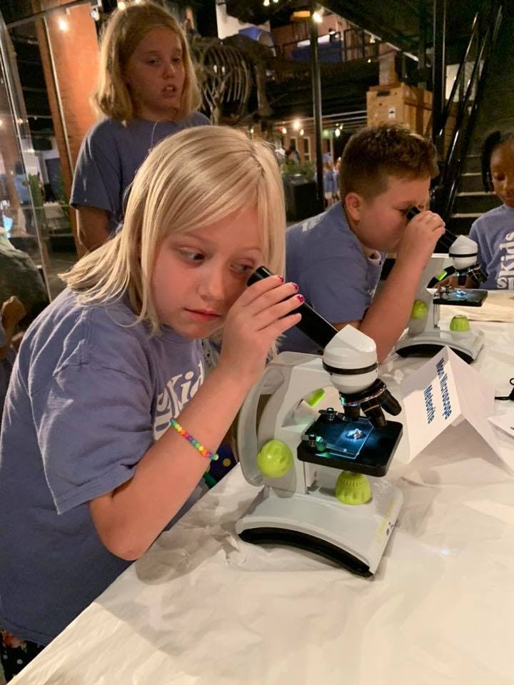 Child looking into a microscope