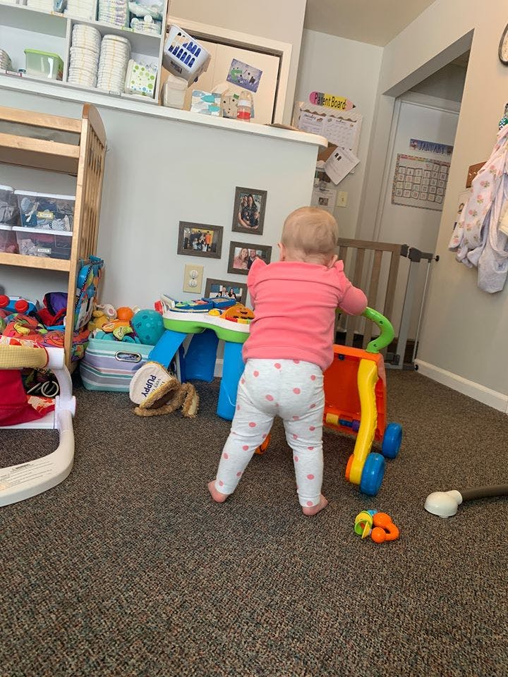 Child standing and pushing a toy walker