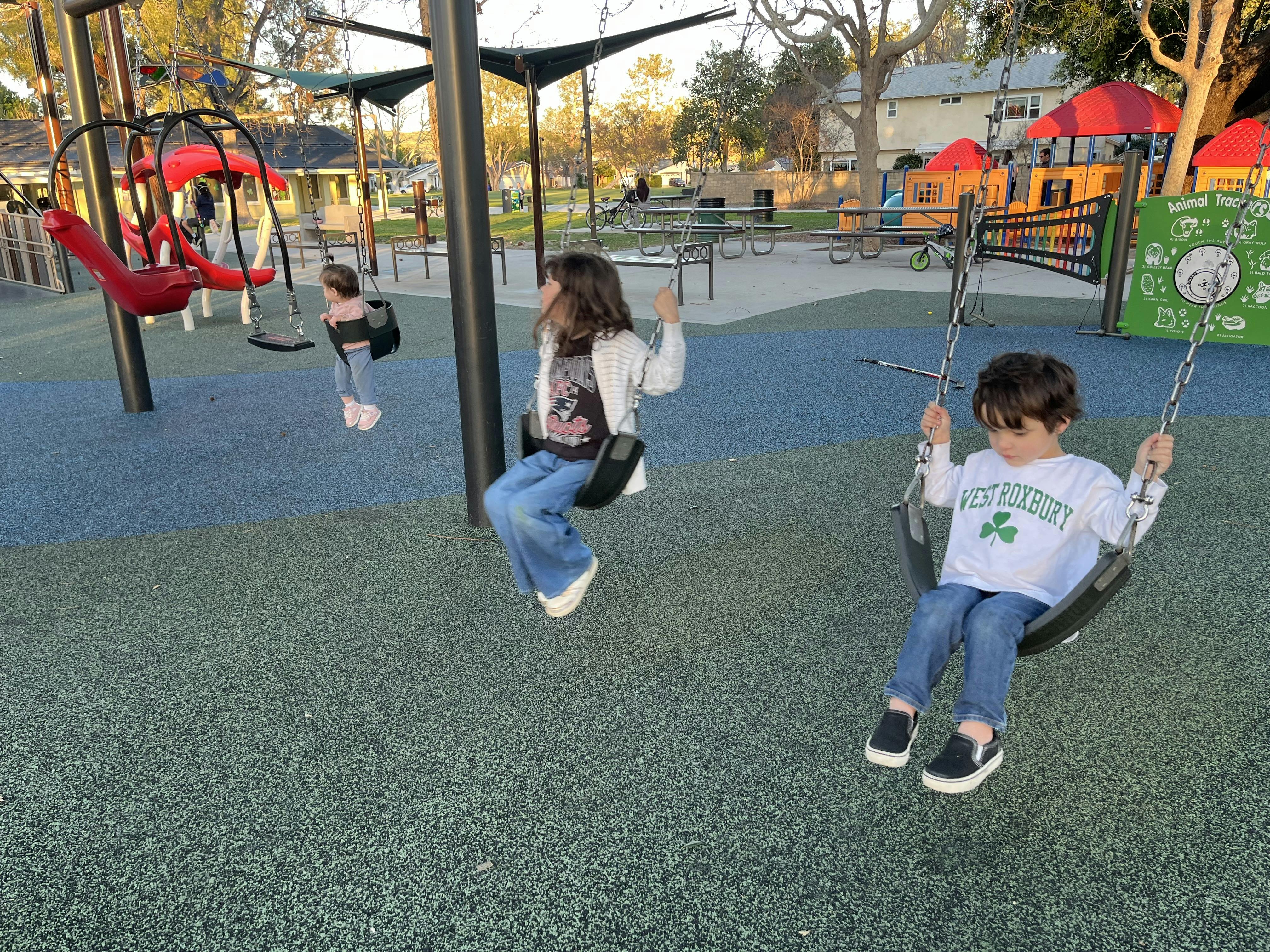 Three children on swings at a playground