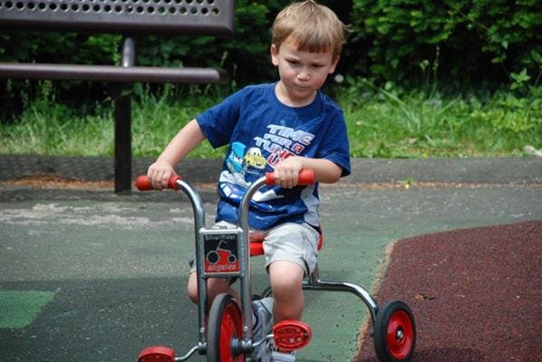 Child riding a tricycle outdoors