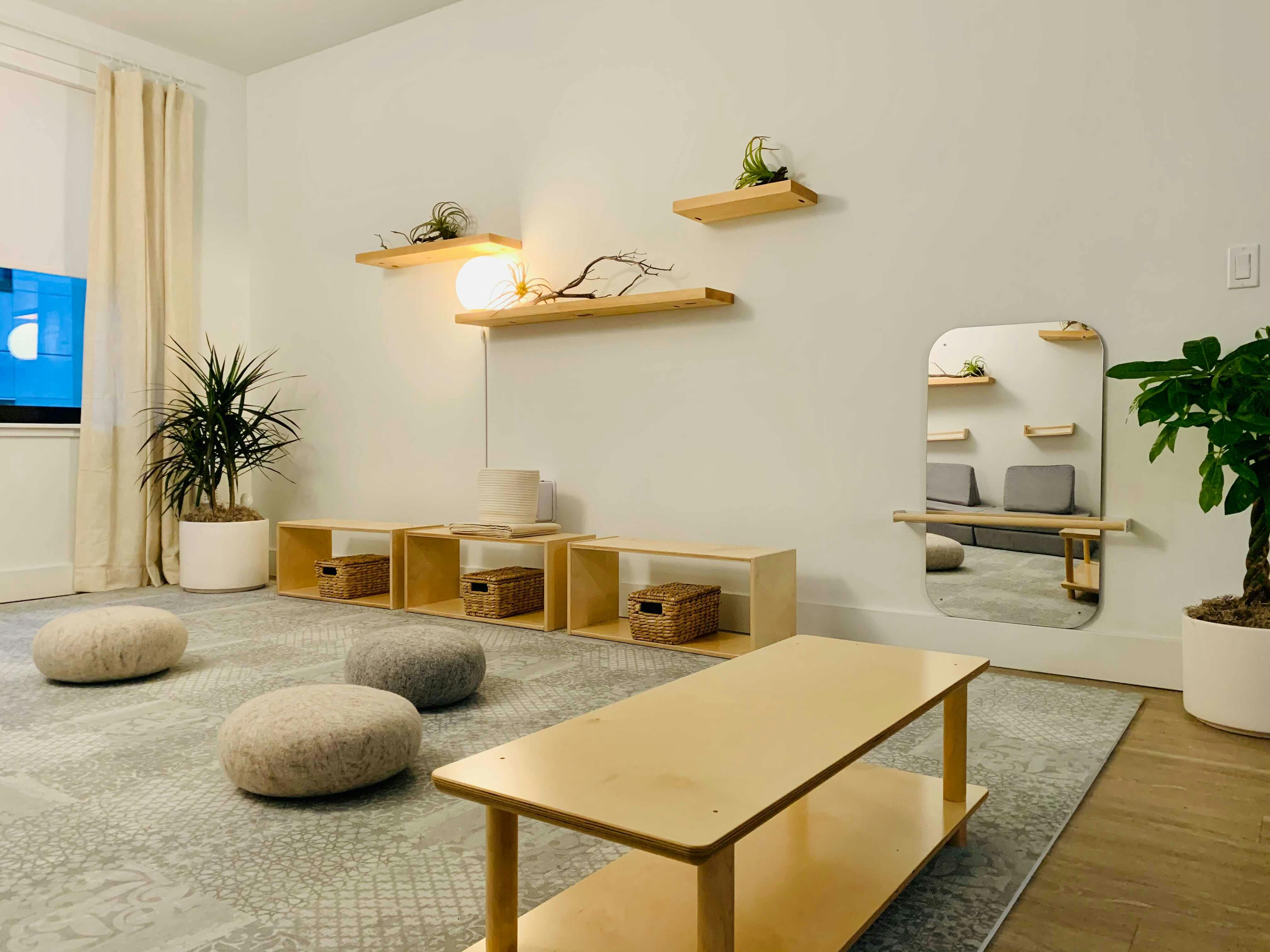 Room with floor cushions, low tables, and wall shelves