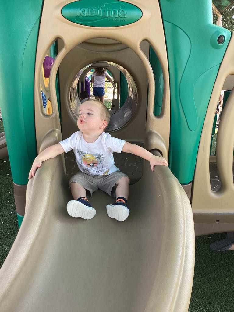 Child sitting on a playground slide