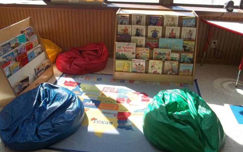 Children's reading nook with beanbags and bookshelves displaying books