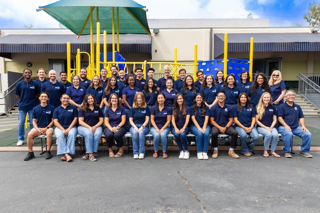 Group of adults posing for a photo on a playground