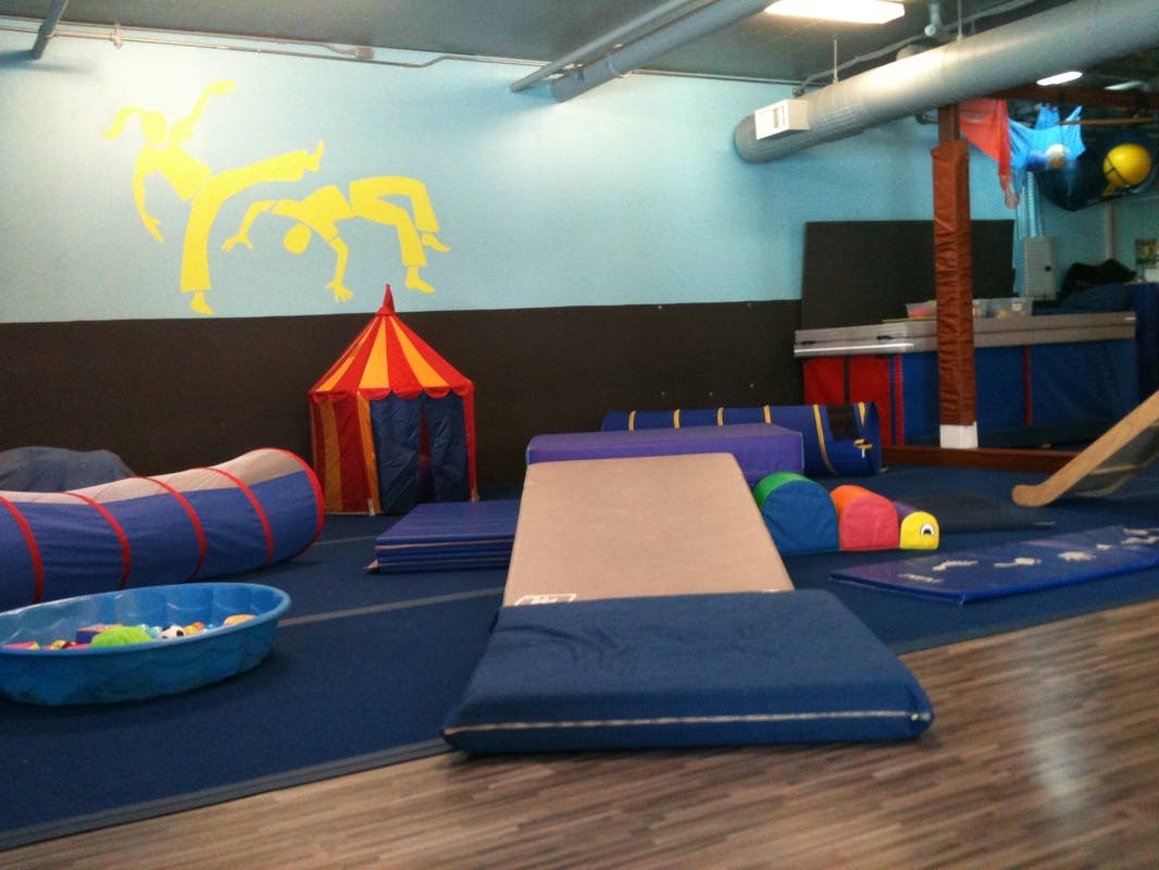 Indoor play area with mats, tunnels, and a small tent