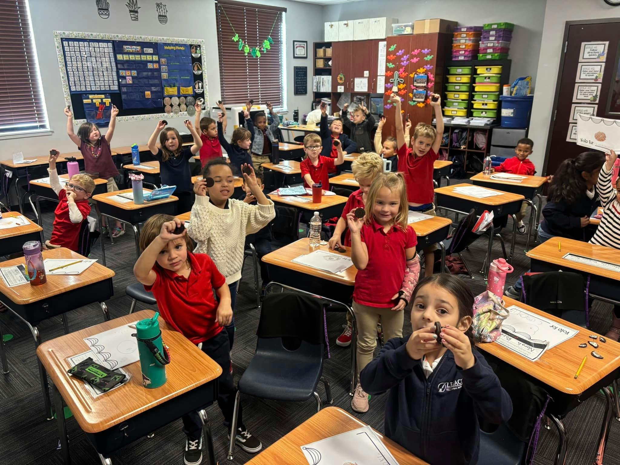 Children in a classroom raising their hands