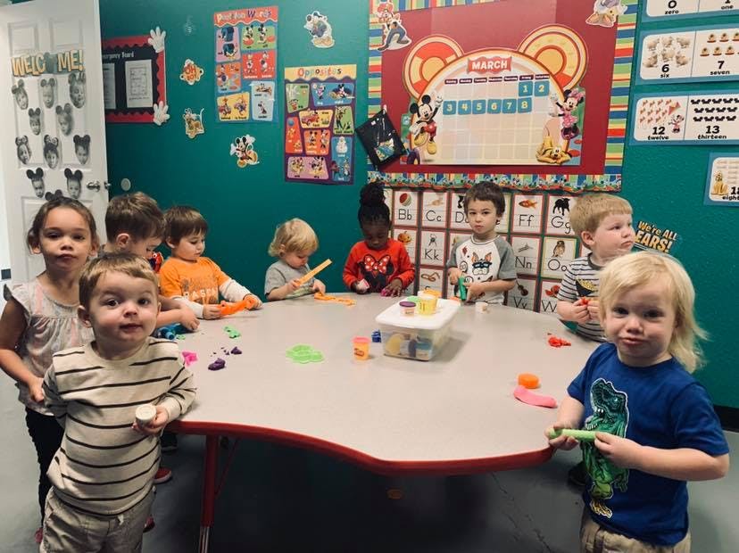 Children sitting around a table with playdough