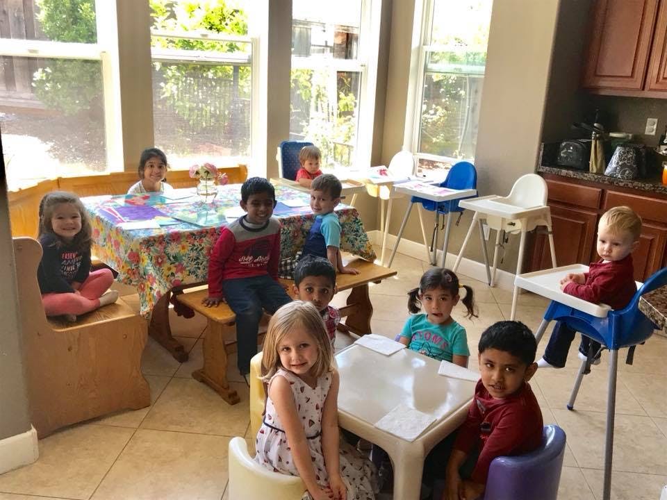 Multiple children sitting at tables in a bright room