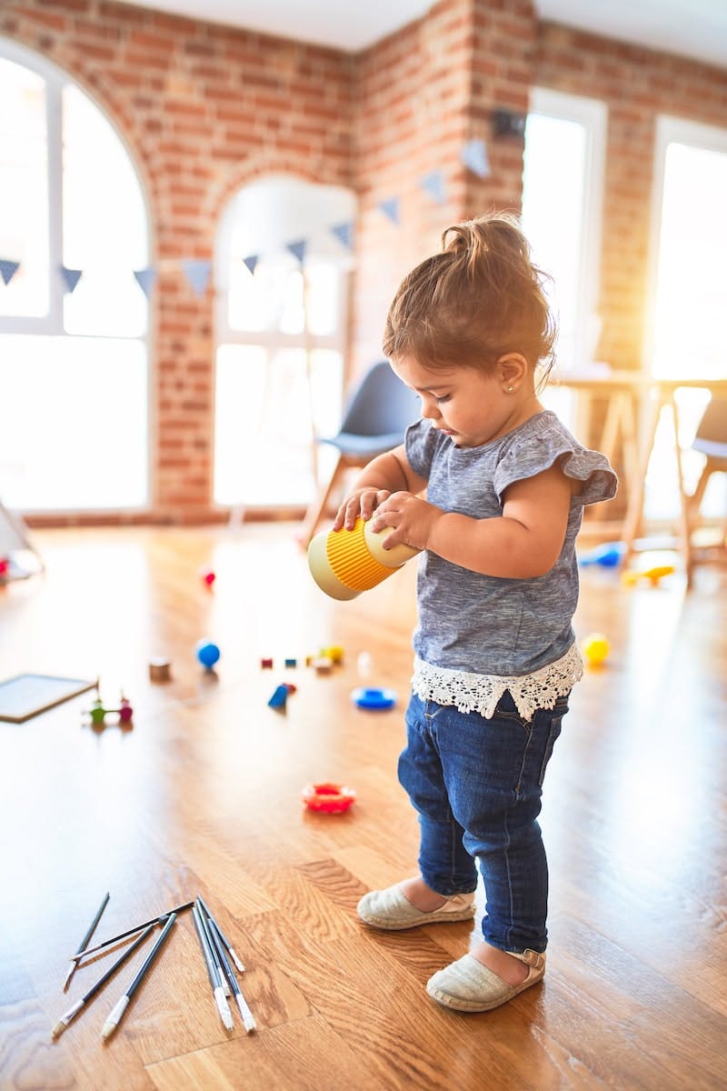 Child standing and holding a yellow cup