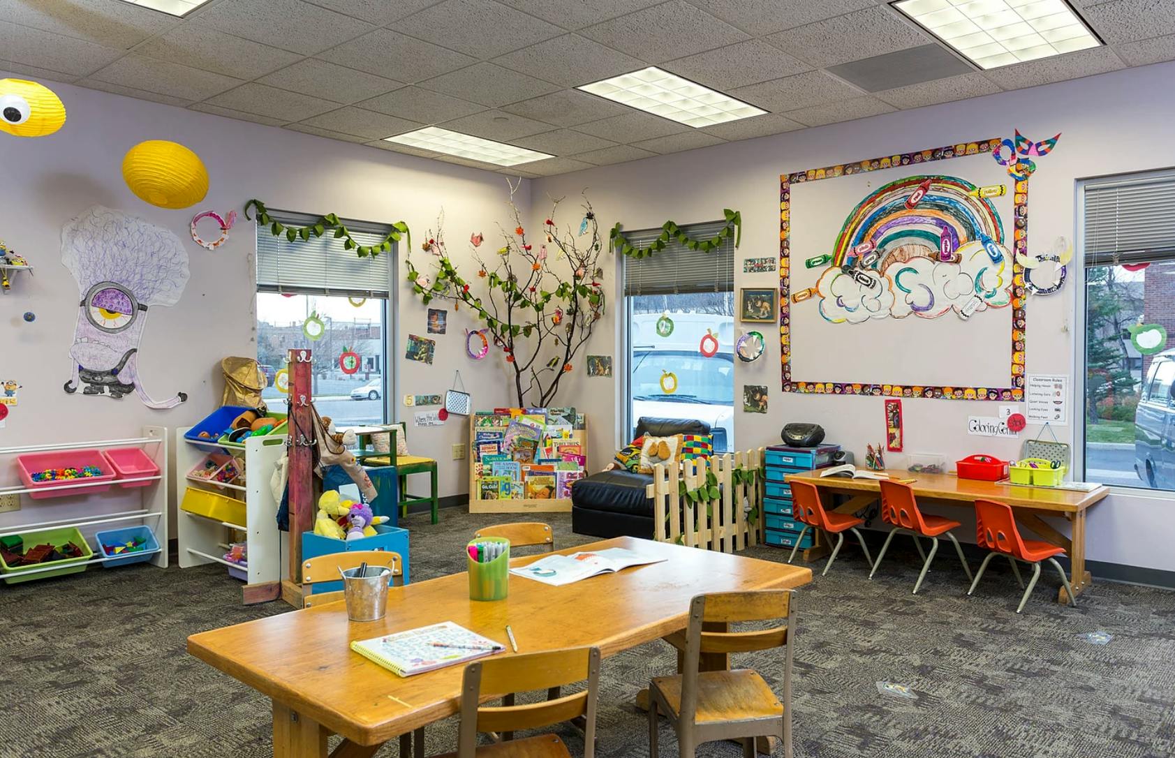 A colorful classroom with tables, chairs, and children's decorations