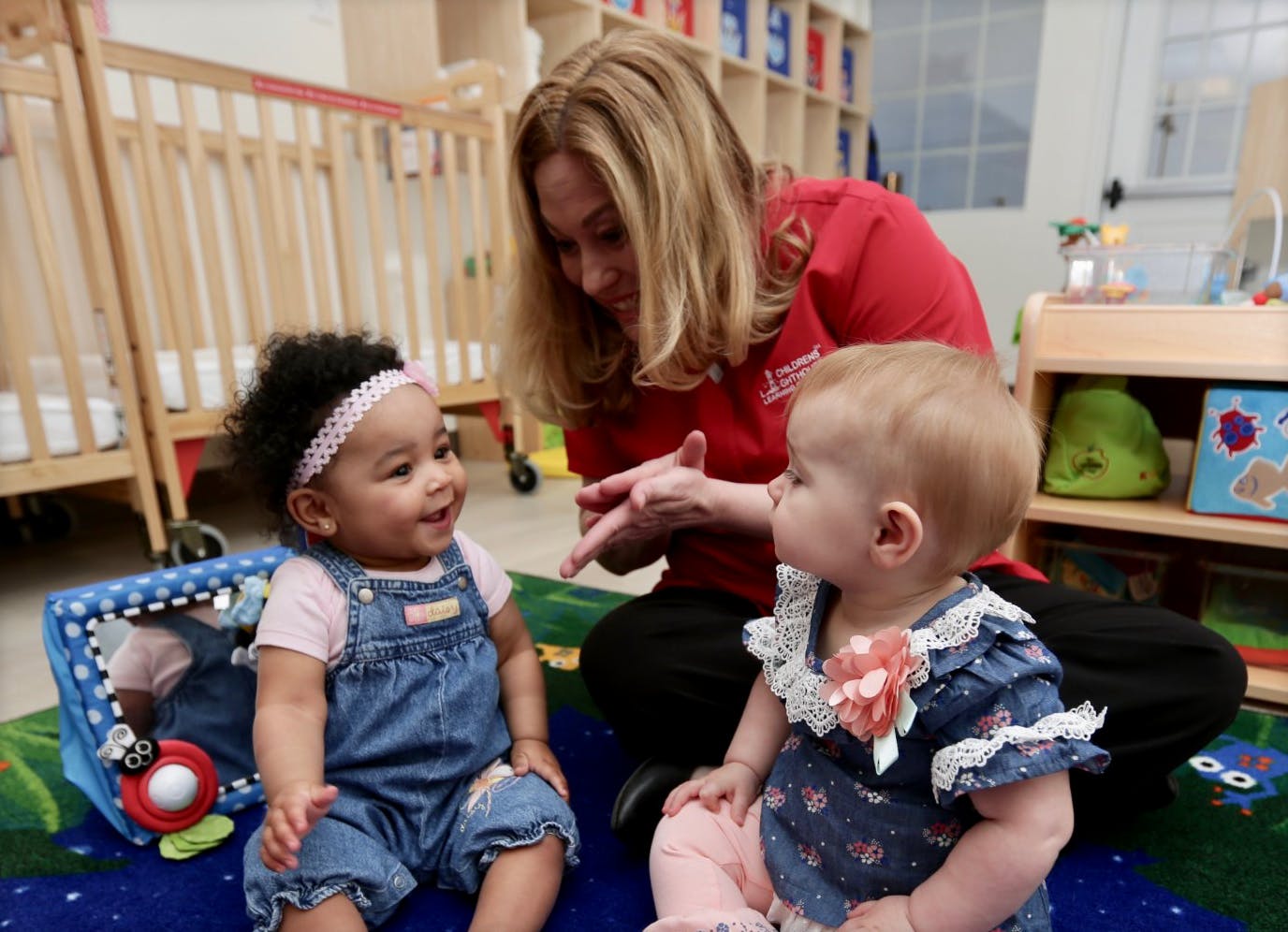 Adult interacting with two children in a classroom