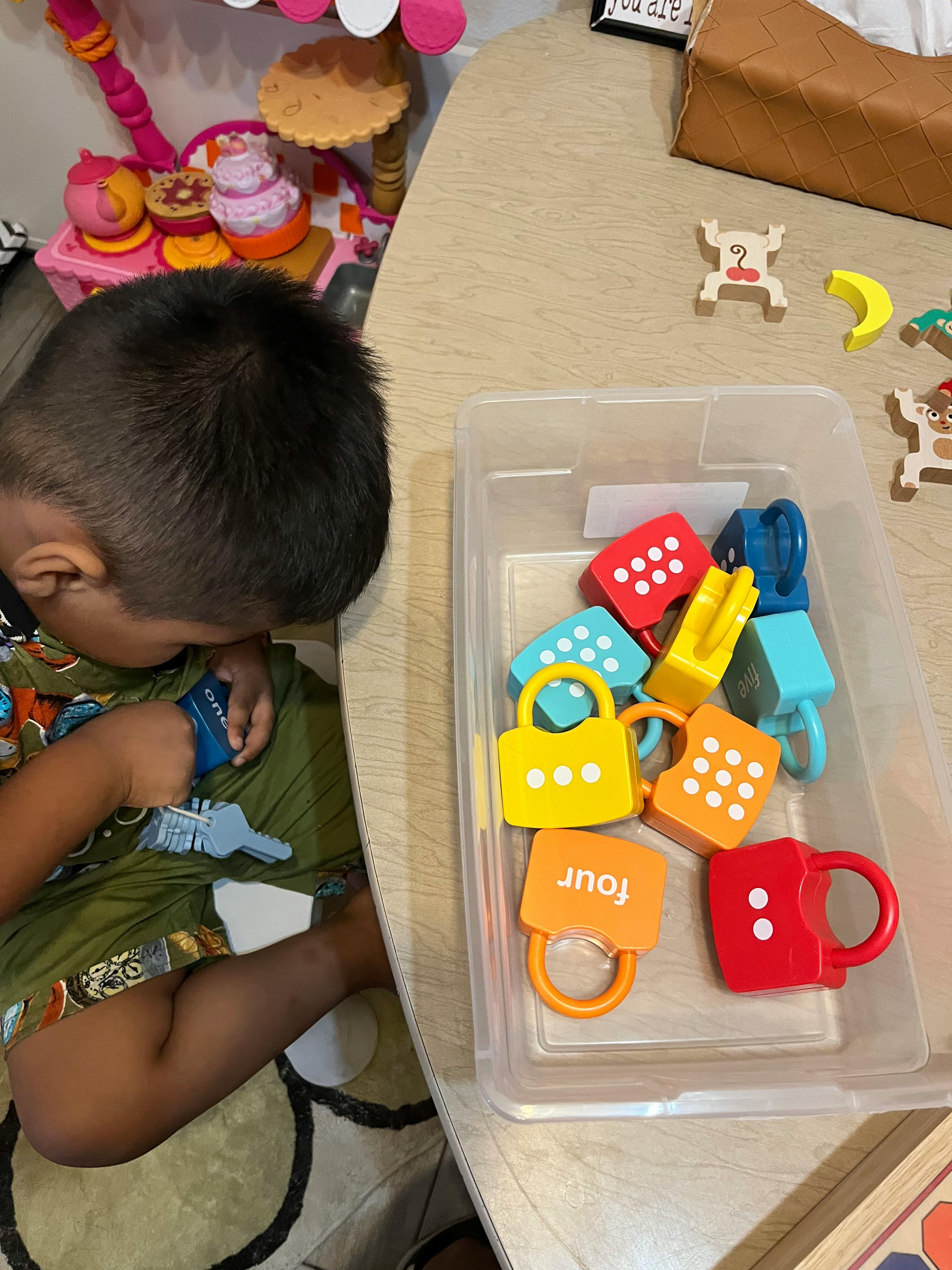 Child playing with colorful toy locks and keys