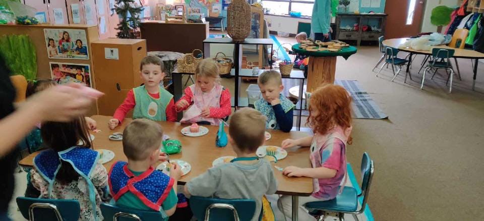 Children sitting at a table in a classroom