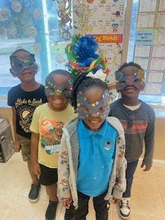 Four children wearing masks