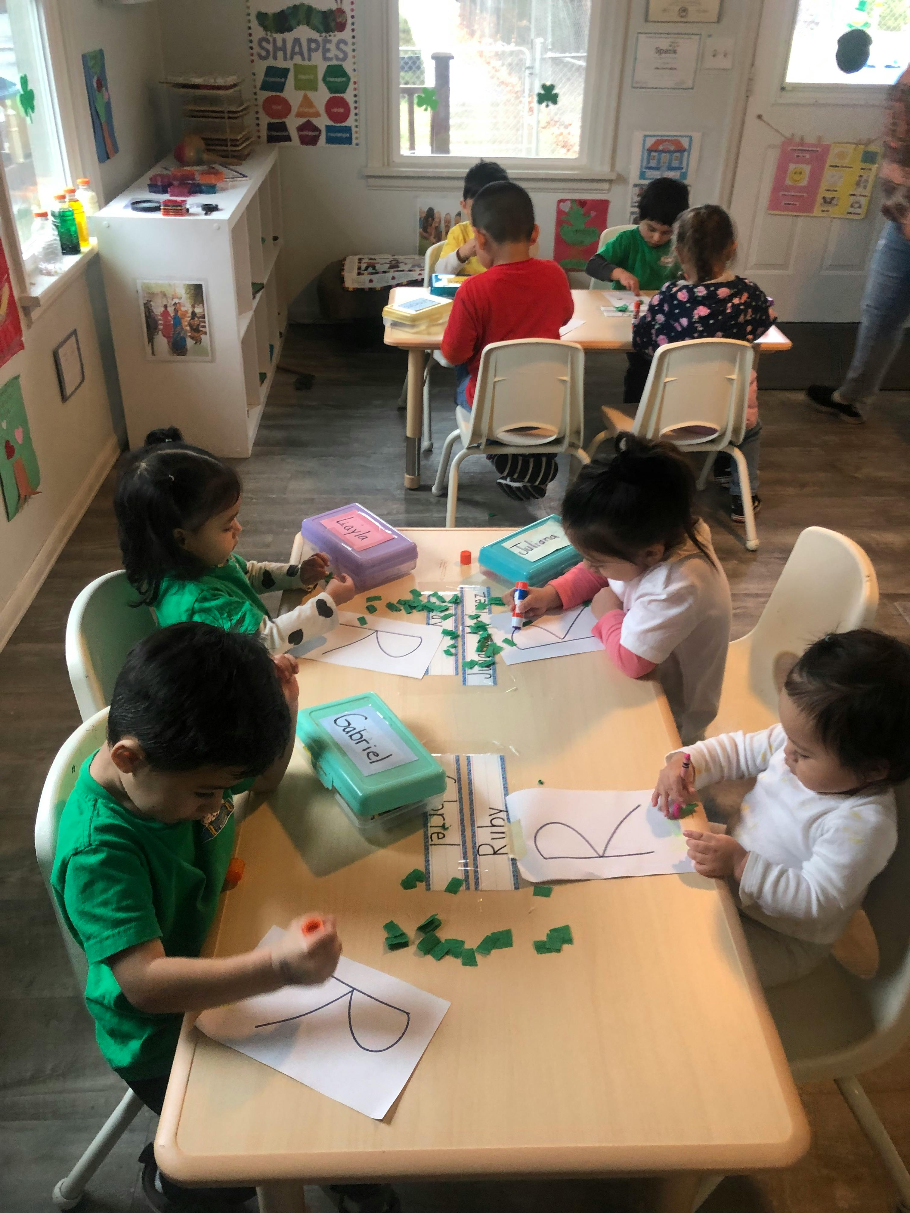 Children sitting at tables doing crafts in-class activities