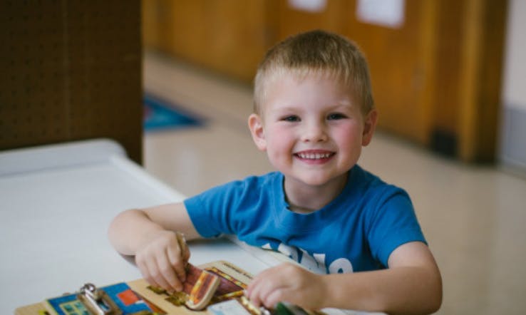 Child playing with a wooden puzzle