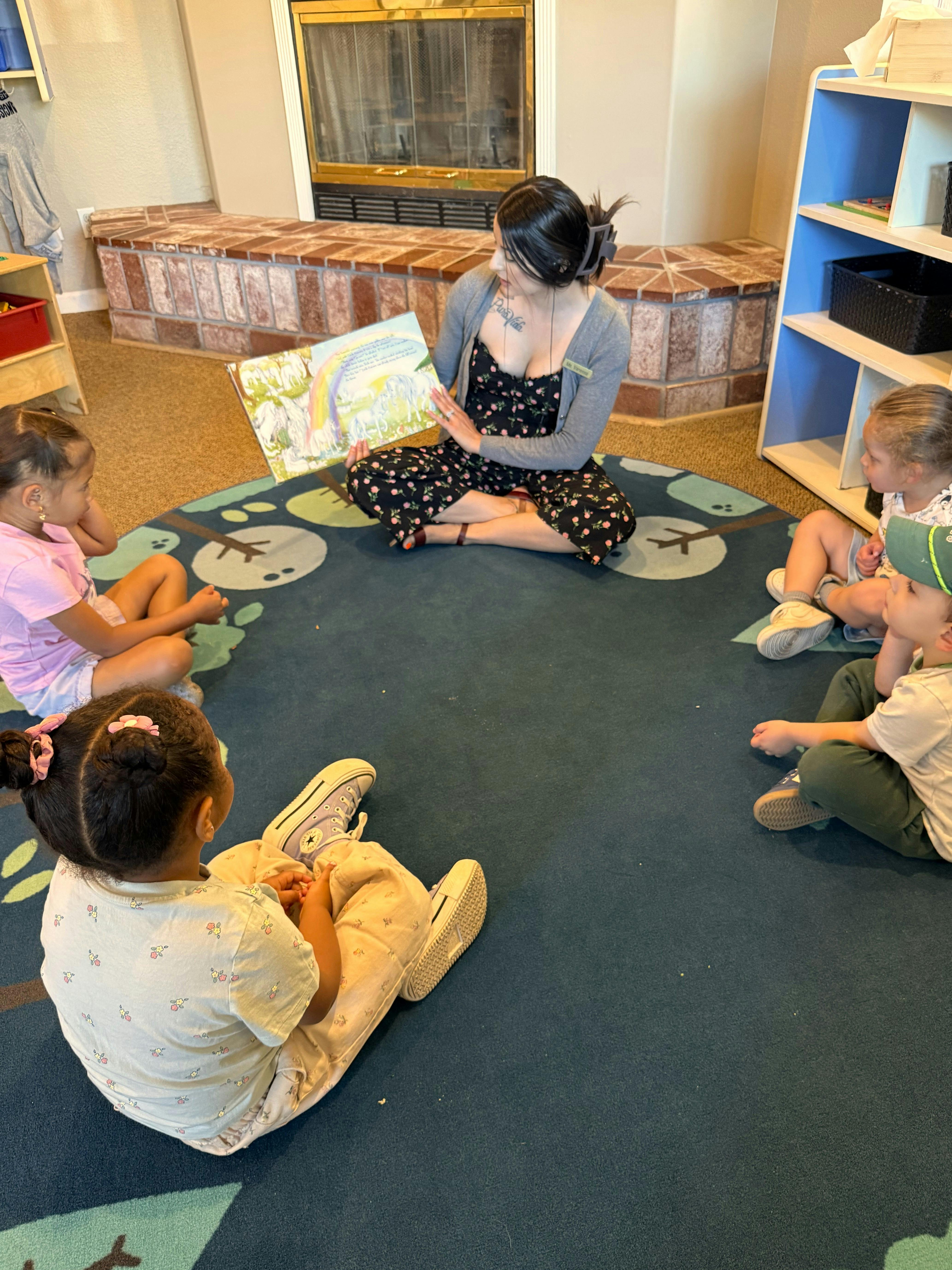 Adult reading a book to children sitting in a circle on a rug