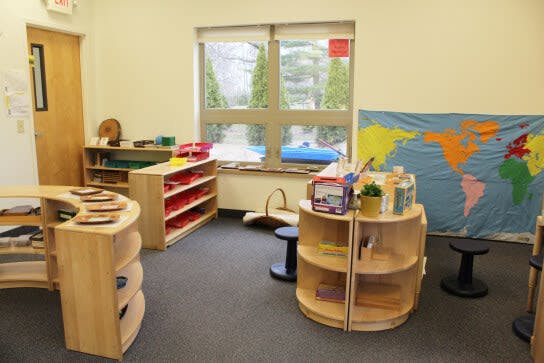 Classroom with wooden shelves, a world map, and a large window
