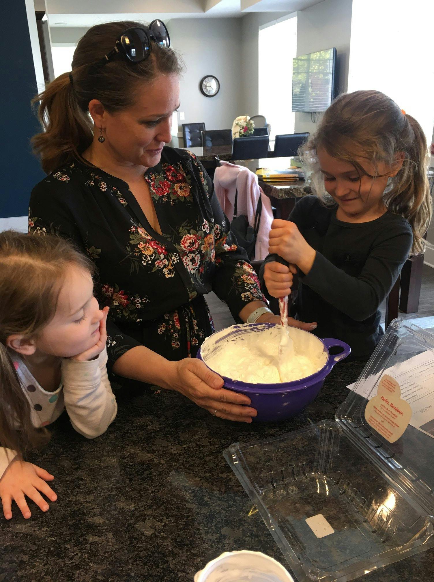 Person and two children mixing ingredients in a bowl