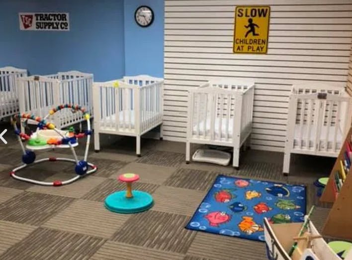 Multiple white cribs and baby play equipment in a room
