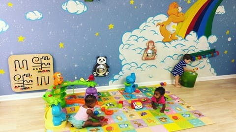 Three children playing with toys in a colorful room
