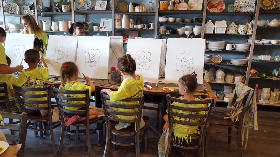 Children painting at easels in a studio