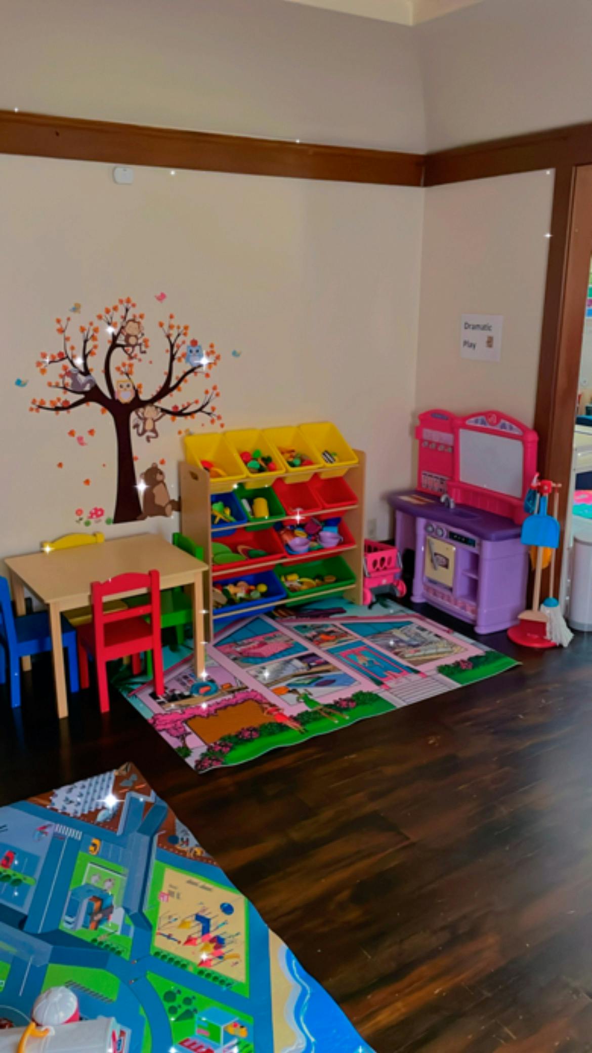 Playroom with toy storage, small table and chairs, and play kitchen
