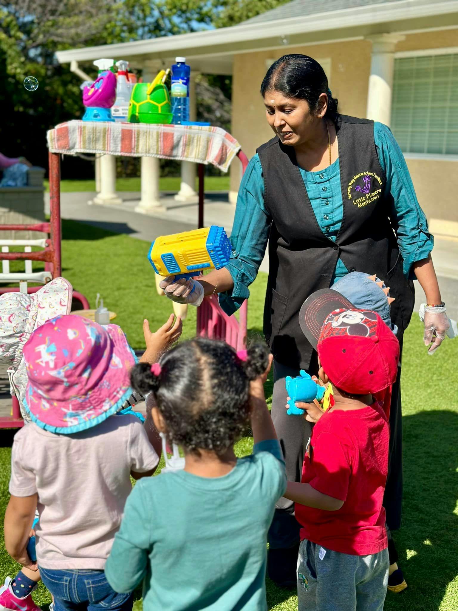 Person holding a bubble gun with children reaching for bubbles